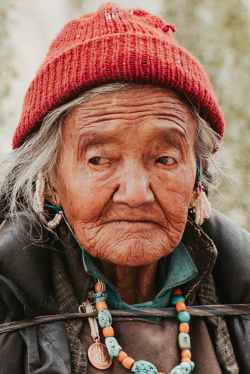 close up photo of an old woman wearing red knit cap